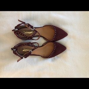 Burgundy flats with cross straps and silver studs.